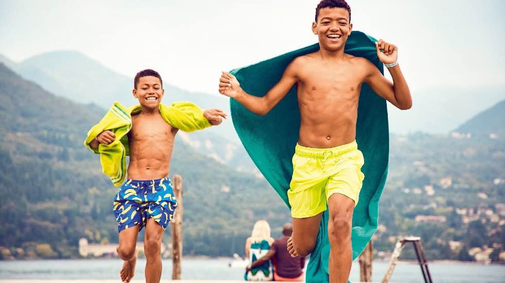 Children in swimming shorts running